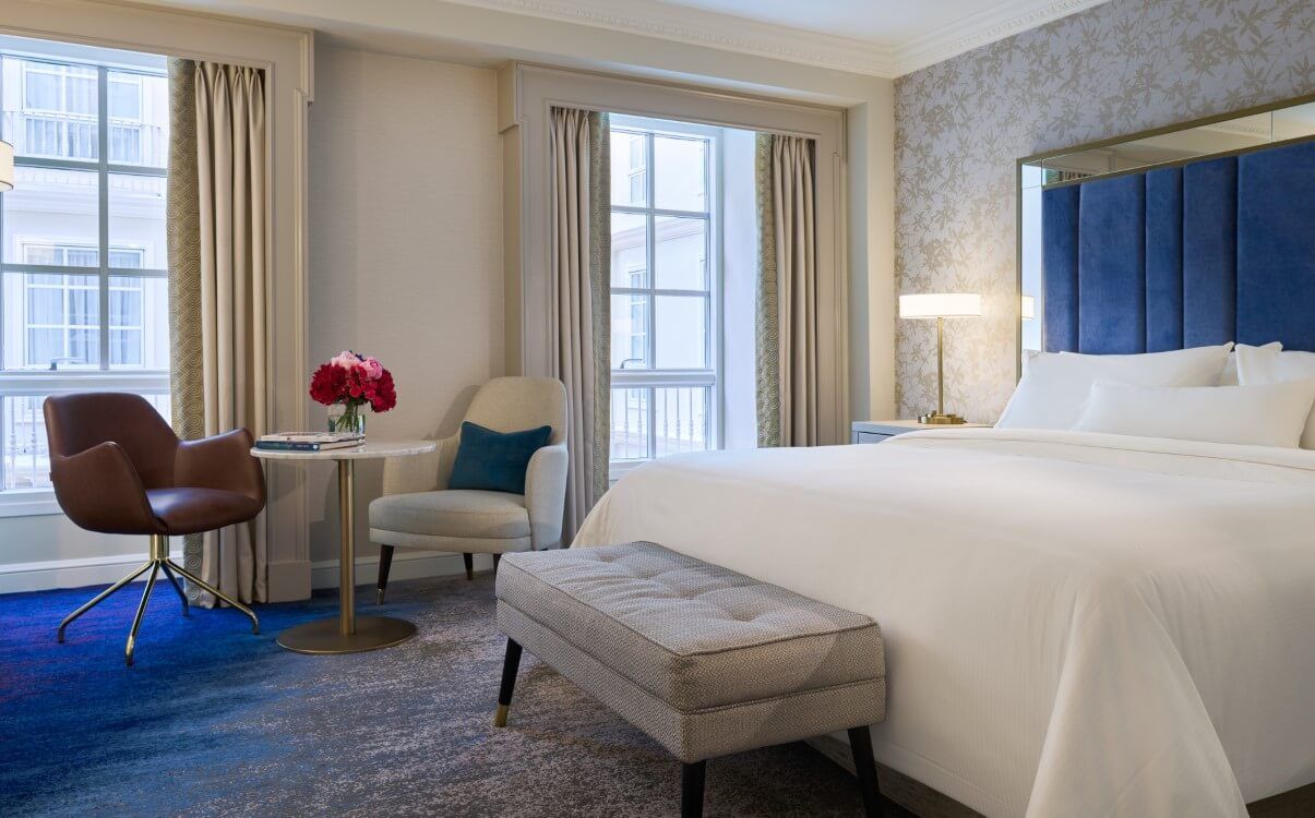 Large king room with blue headboard, open curtains and view over Atrium in The College Green Hotel Dublin
