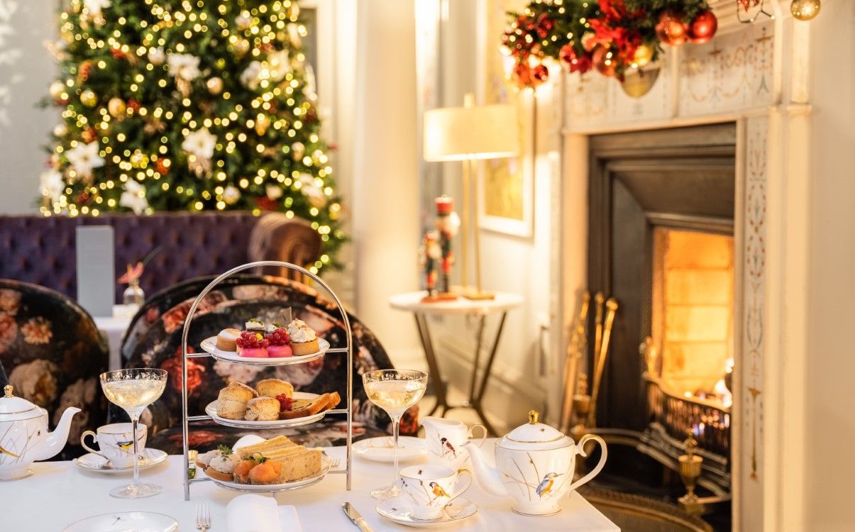 Festive Afternoon Tea set on table with champagne, next to fire